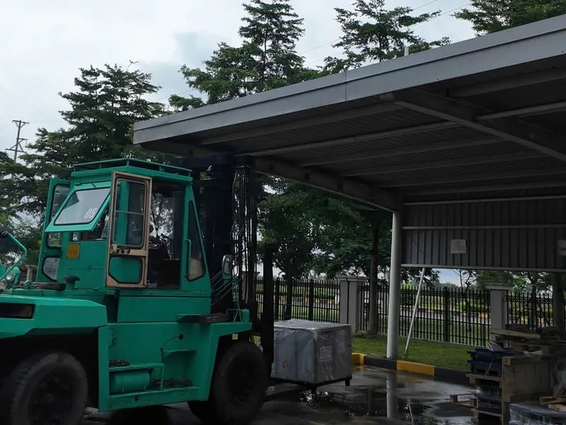 Xe nâng xanh đặt kiện máy đúng vị trí